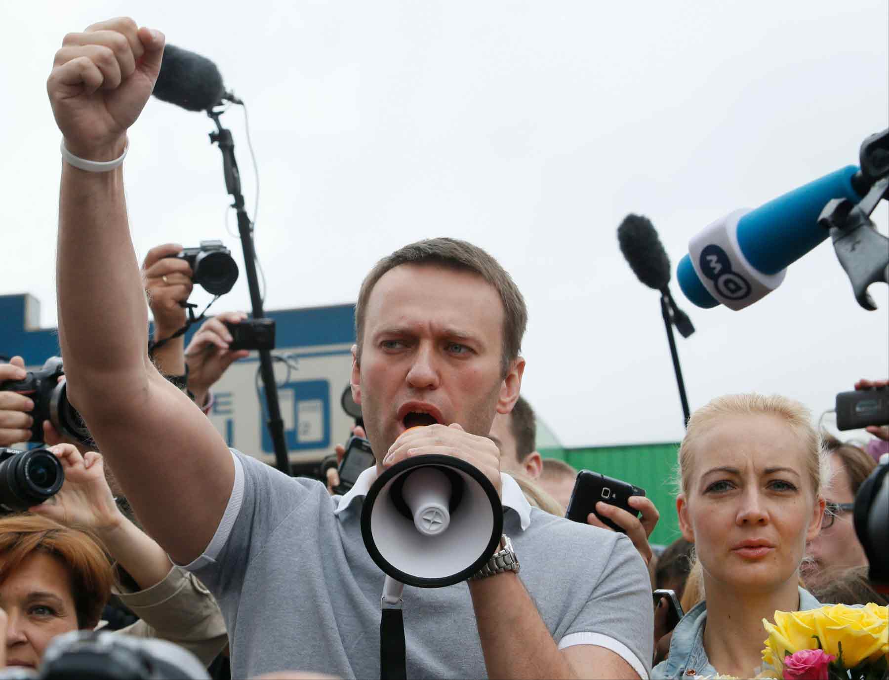 Russian opposition leader Alexei Navalny, foreground center, his wife Yulia, left, and his former colleague Pyotr Ofitserov, second left in front, address supporters and journalists after arriving from Kirov at a railway station in Moscow, Russia, Saturday, July 20, 2013