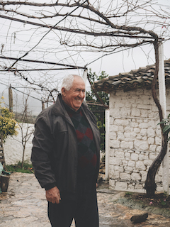 Bujar Haxhaj, 72, at his garden in front of his house in Kutë